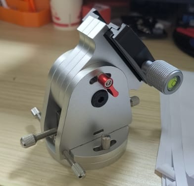 Precision CNC machined aluminum optical mount with clear, black, and red anodized components and integrated bubble level.