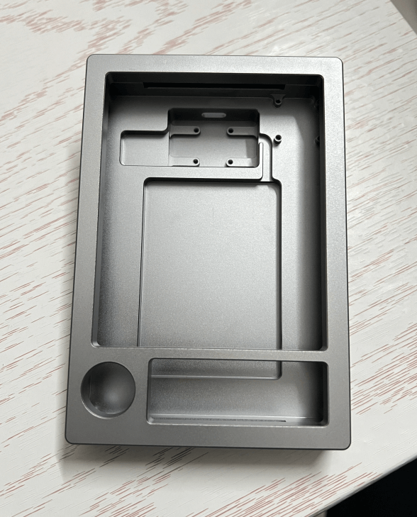 Precision CNC machined aluminum housing with deep internal pockets and matte silver anodized finish.