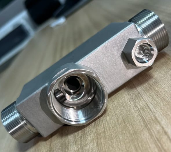 Custom CNC machined aluminum hydraulic manifold with bead blast finish and threaded ports.