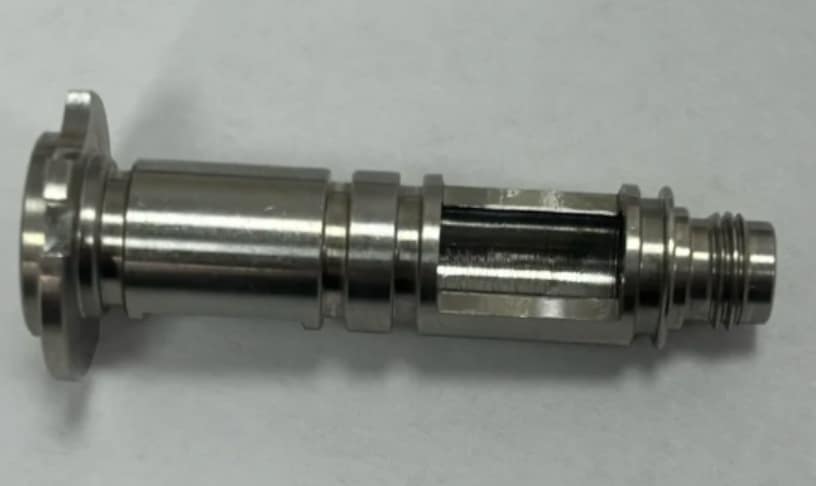 Stainless steel spool valve component showing milled pocket, external threads, and polished surface finish.